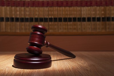 A judge 's gavel on top of a wooden table.